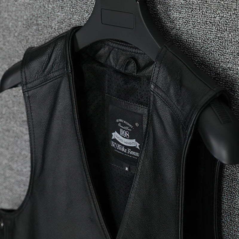Close-up of a black collarless genuine leather vest hanging, showcasing its sleek biker style and interior label.