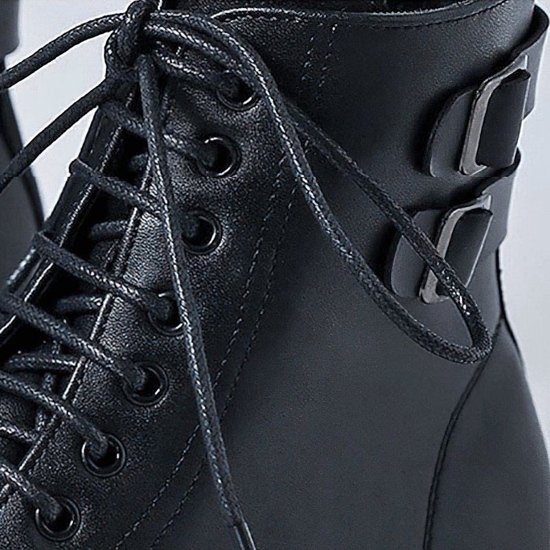 Close-up of men's black lace-up ankle boots with stylish buckle detail and quality leather finish.