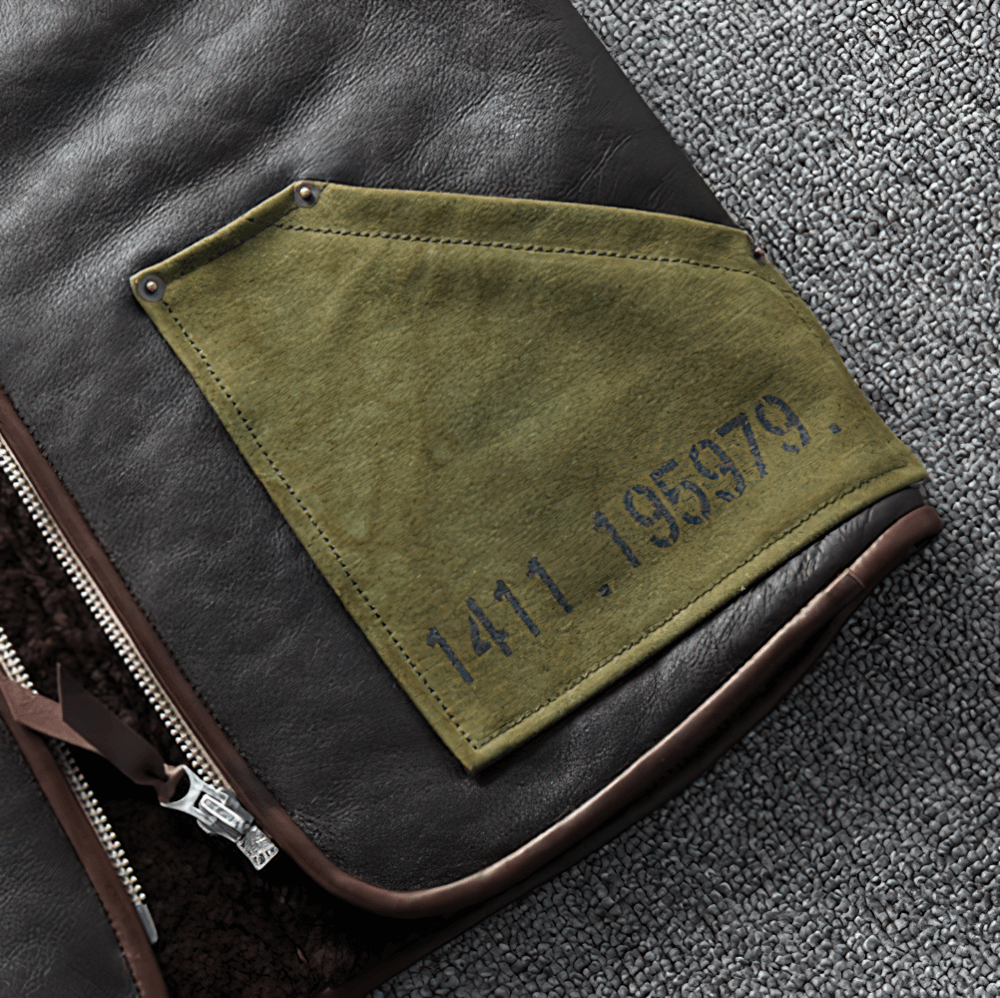 Close-up of black leather biker vest with green pocket detailing and vintage design elements.