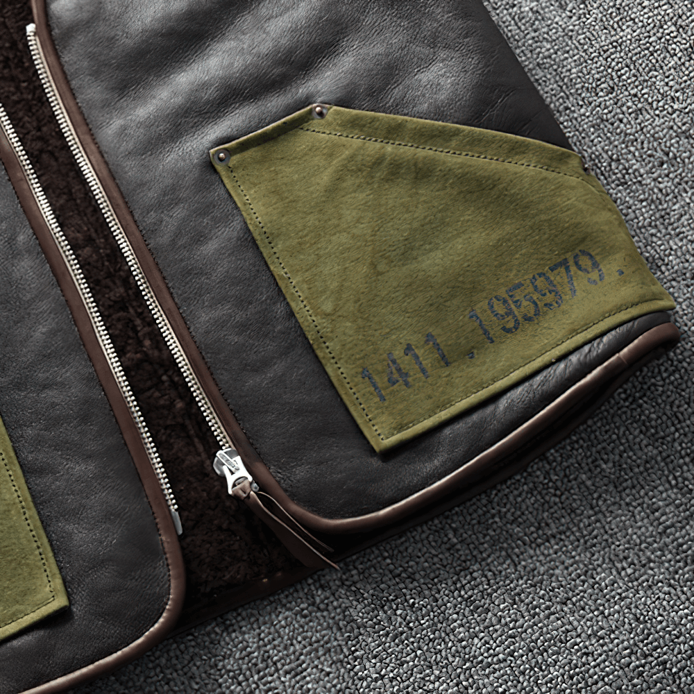 Close-up of black leather biker vest featuring green pockets and zipper detail, showcasing vintage style for men.
