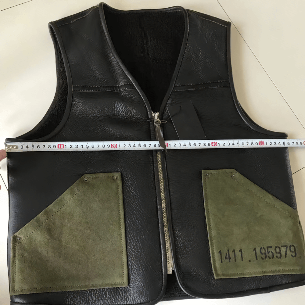 Men's black leather biker vest with green pockets, showcasing quality craftsmanship and stylish vintage flair.