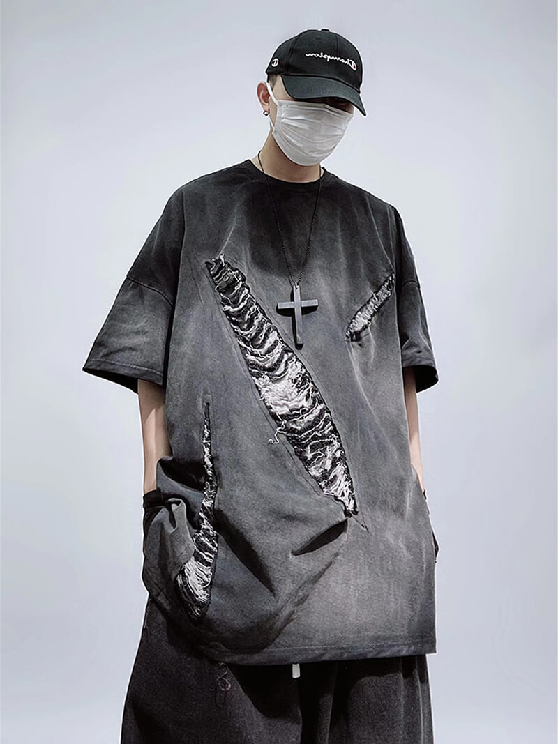 Trendy oversized hole-ripped T-shirt on model, showcasing edgy vintage style in relaxed fit.