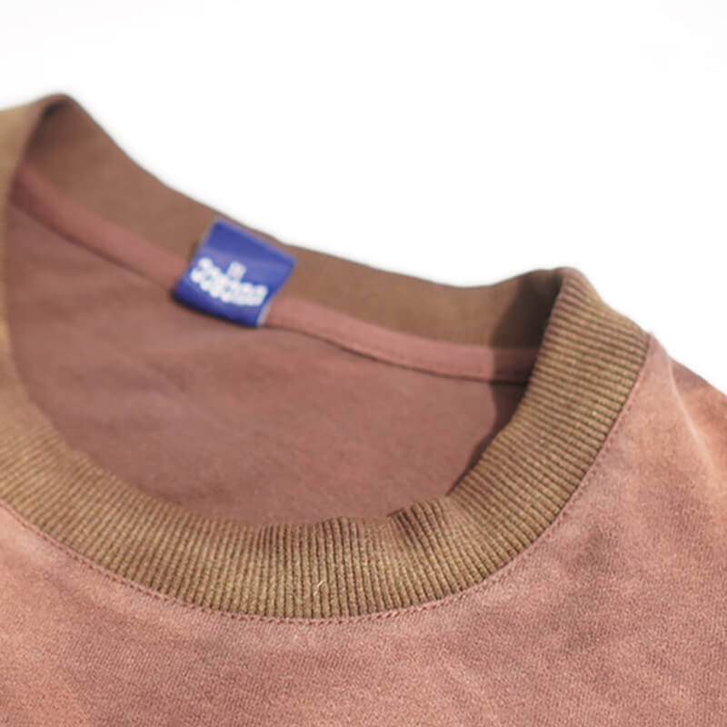 Close-up of a vintage brown oversized hole-ripped T-shirt with a classic O-neck design.