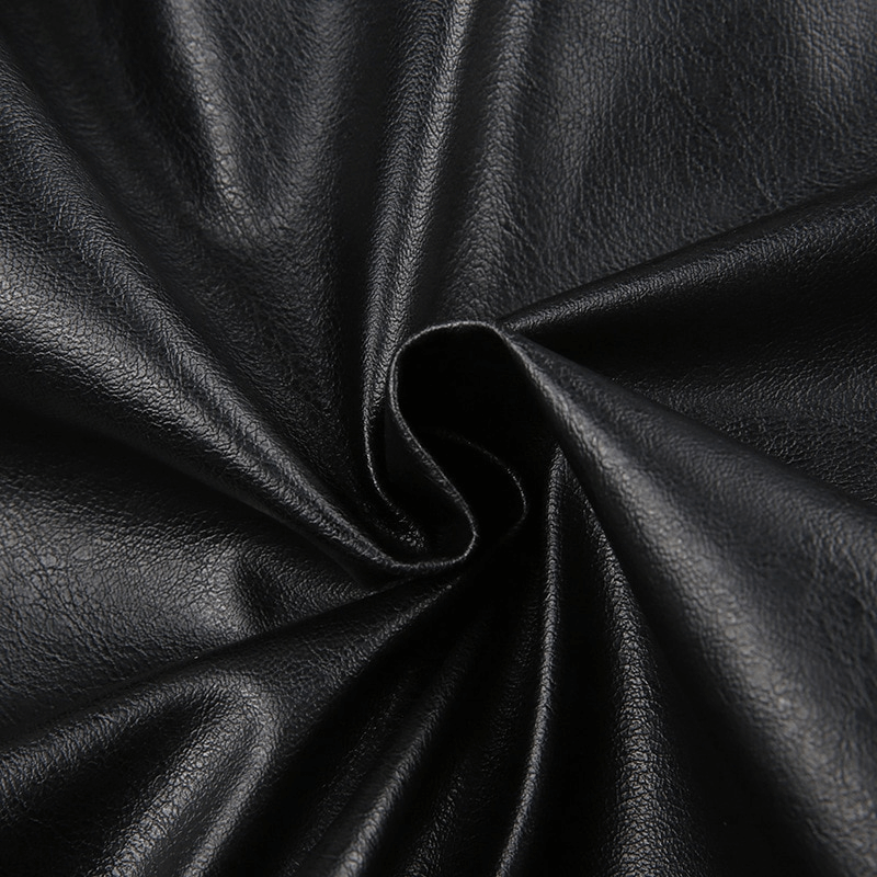 Close-up view of luxurious black PU leather fabric, showcasing its smooth texture and shine, perfect for trendy jackets.