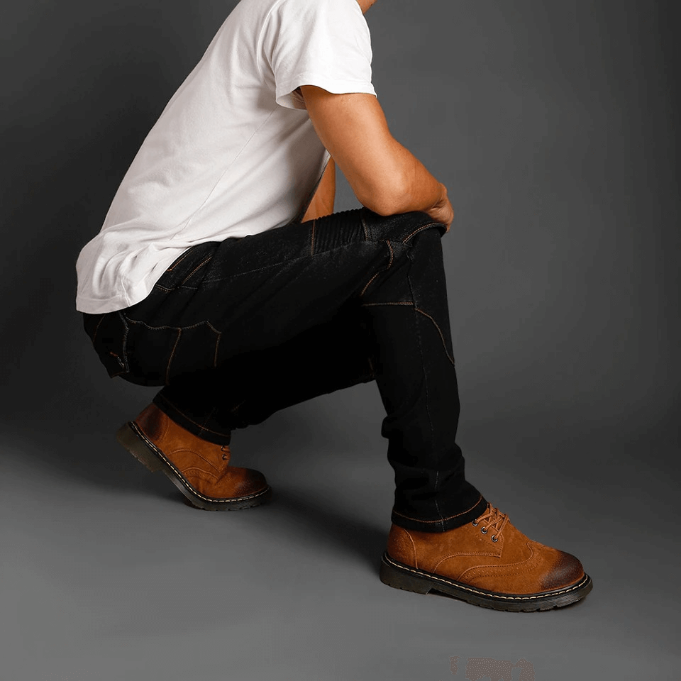 Man wearing black biker jeans and brown boots, showcasing stylish protective pants for bikers.