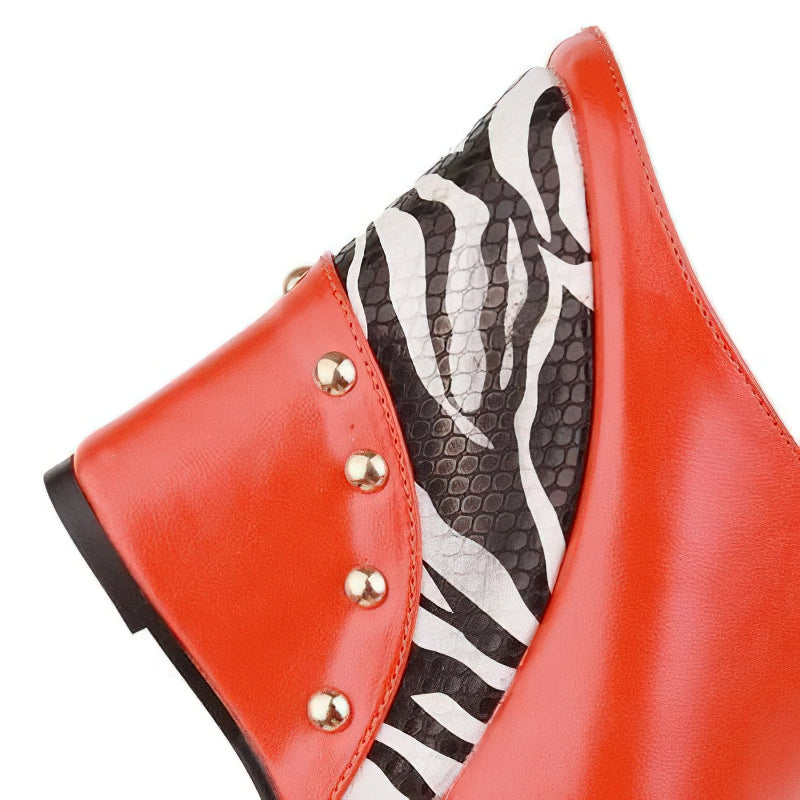 Close-up of stylish orange high heel sandals with zebra print and decorative studs, perfect for summer fashion.