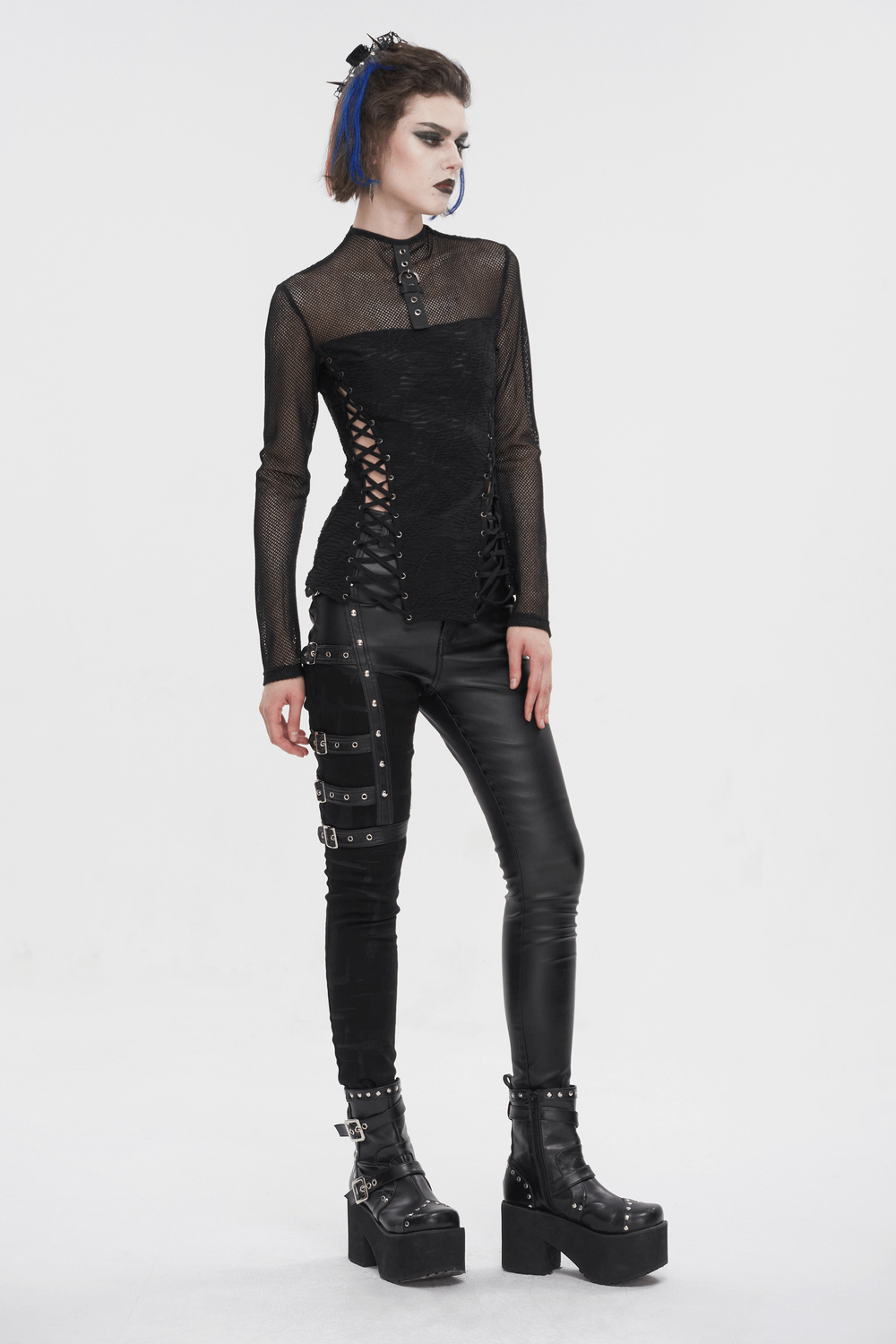 Fashionable woman in black mesh and leather multi-buckle pants, showcasing a punk style look with edgy details.