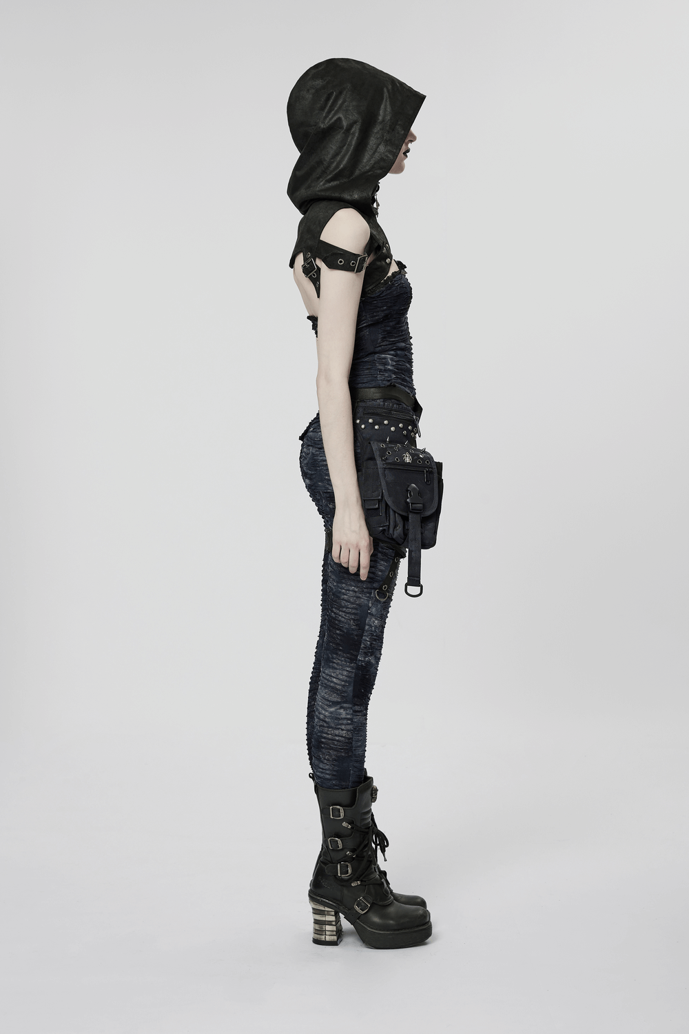 Side view of a model in a cracked faux leather Gothic hooded harness with rivets and skull pendant.