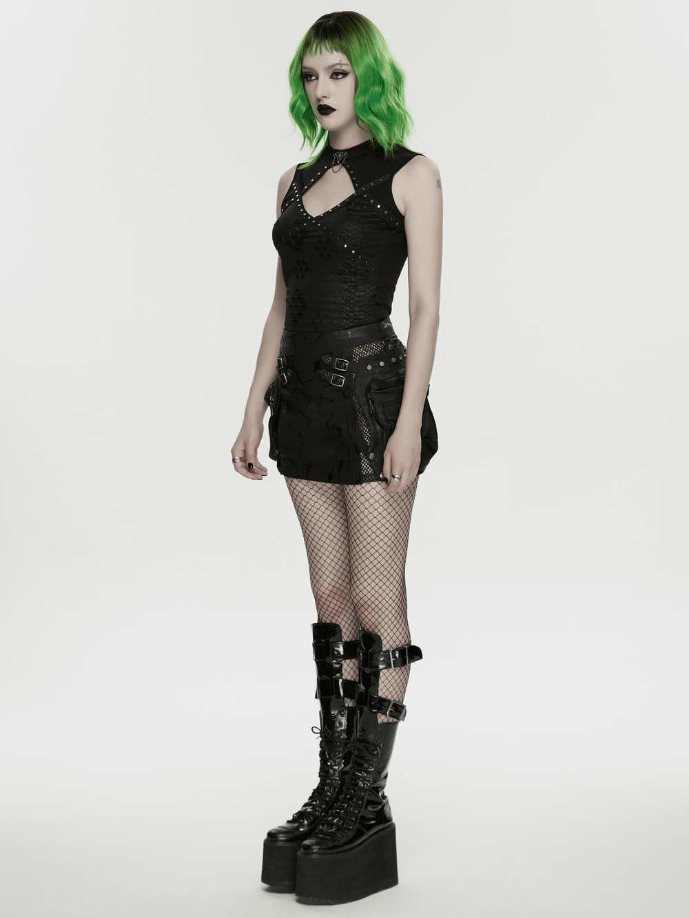 Model wearing Cracked Leather Punk Mini Skirt with Buckles and Bags, styled with fishnets and platform boots.