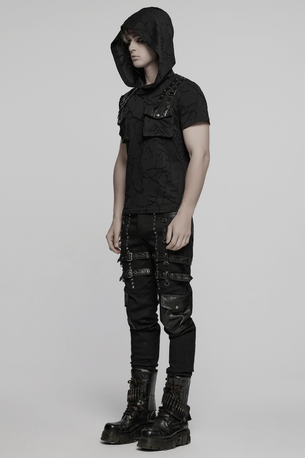 Punk hooded T-shirt with cracked texture, shoulder straps, and dual pockets, styled with edgy black pants.