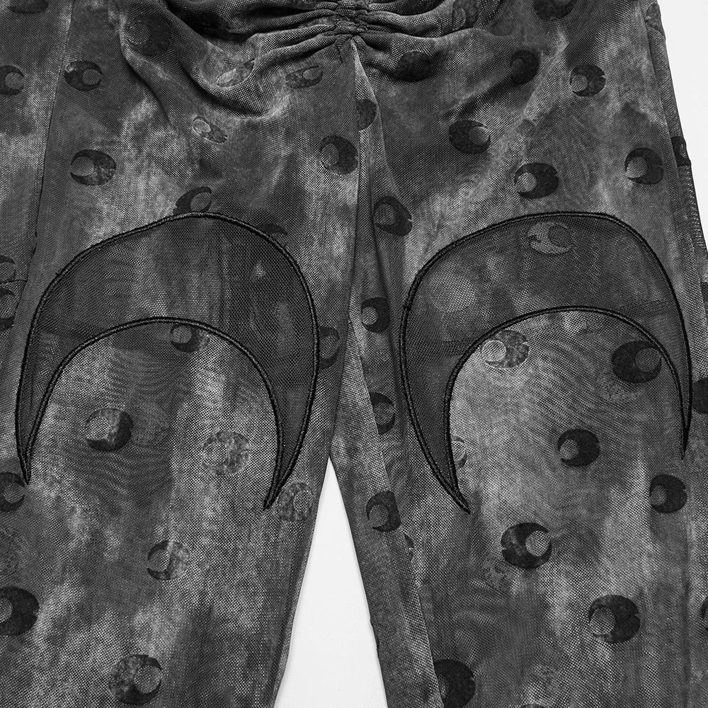 Close-up of crescent moon embroidered mesh flare pants with unique moon print design.