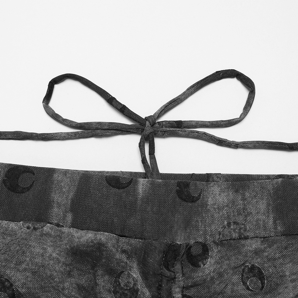 Close-up of crescent moon mesh flare pants waist strap with bow, showcasing unique pleated design.