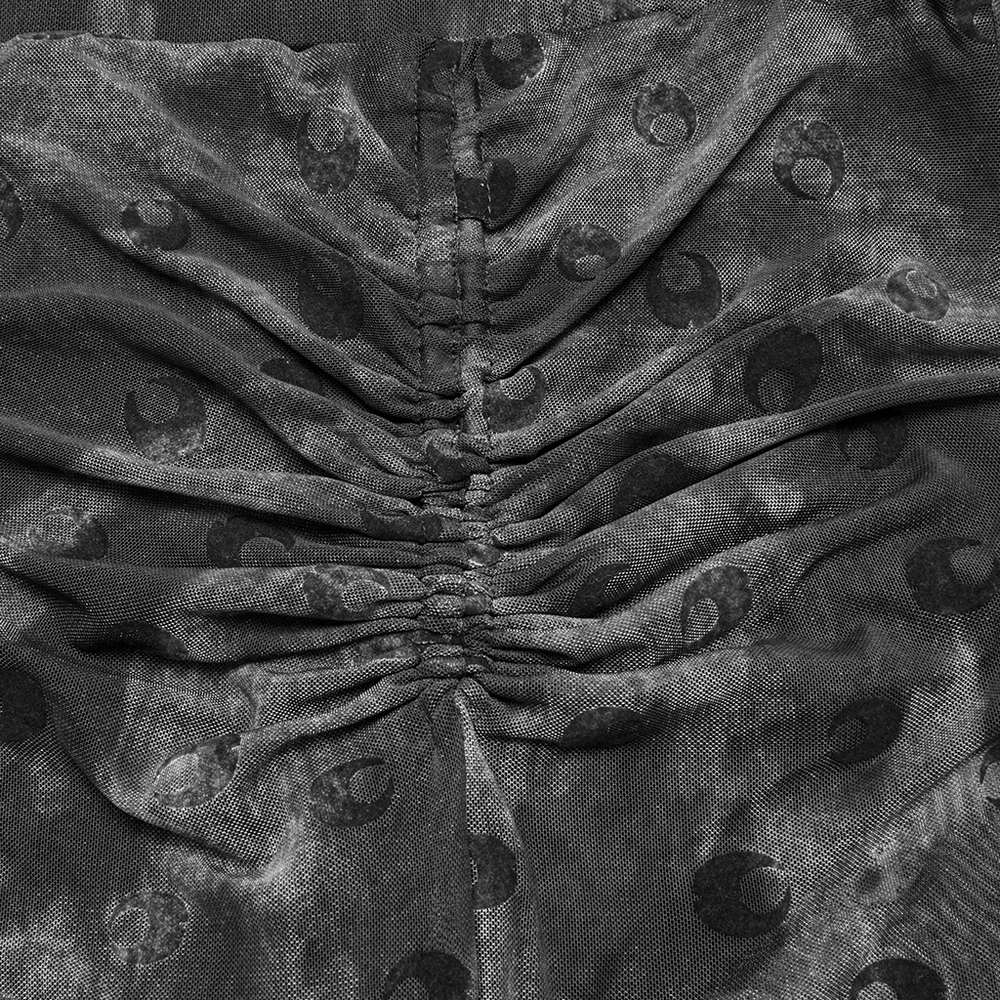 Close-up of crescent moon print and pleated detail on stylish mesh flare pants.