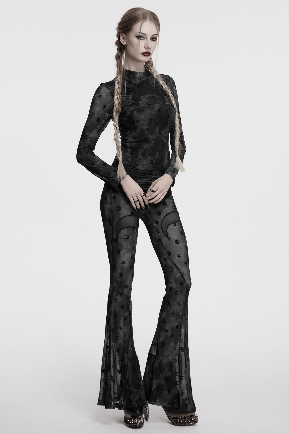 Chic model wearing crescent moon mesh flare pants with pleated waist strap, showcasing bold moon print and stylish fit.