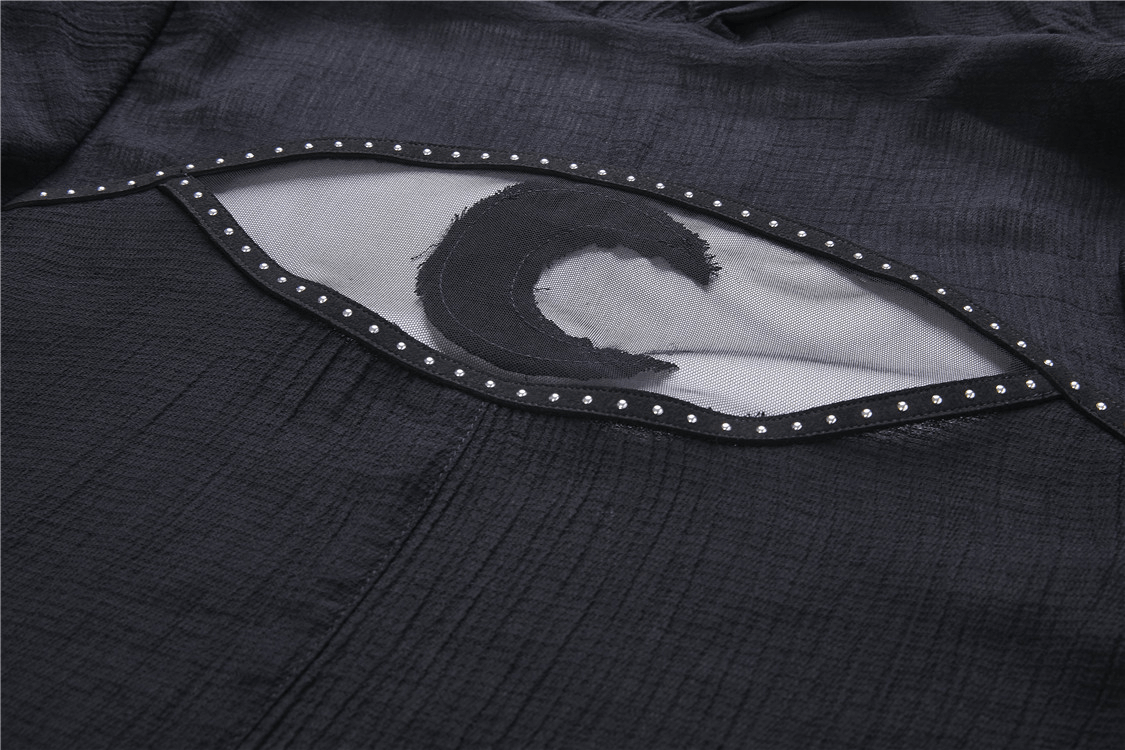 Close-up of crescent moon cut-out in dark fabric of gothic punk hoodie trench coat.