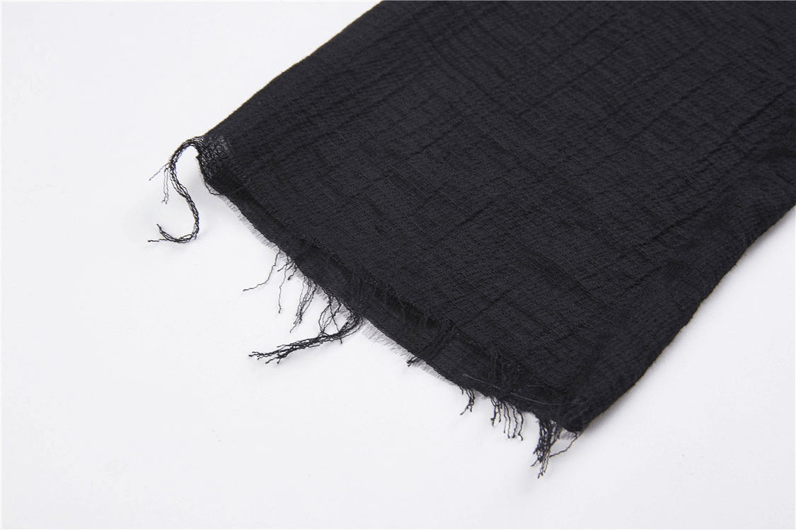 Close-up of the frayed hem of a black fabric, showcasing soft texture for a gothic punk hoodie trench coat.