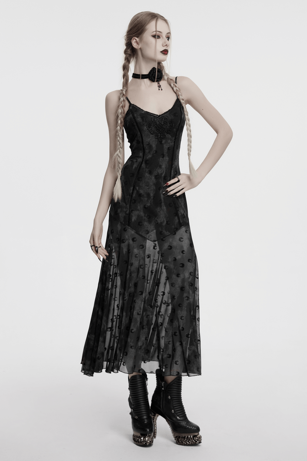 Model in a crescent print two-piece gothic mesh dress with lace details and stylish boots.