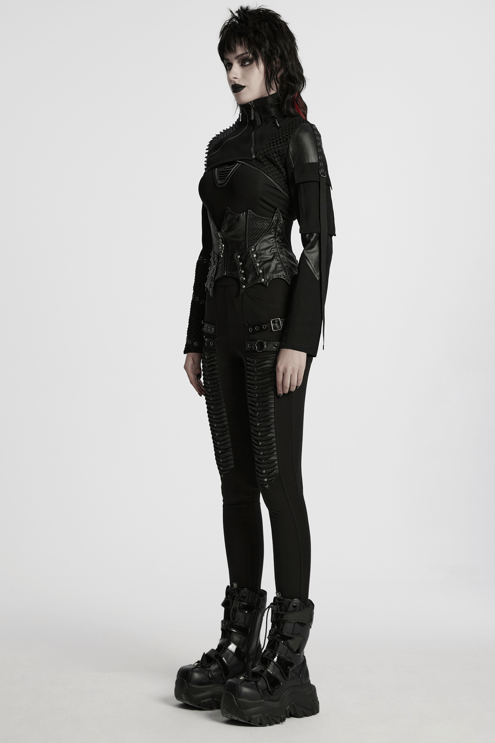 Stylish cyberpunk black cropped jacket featuring zippers and mesh, paired with edgy accessories and chunky boots.