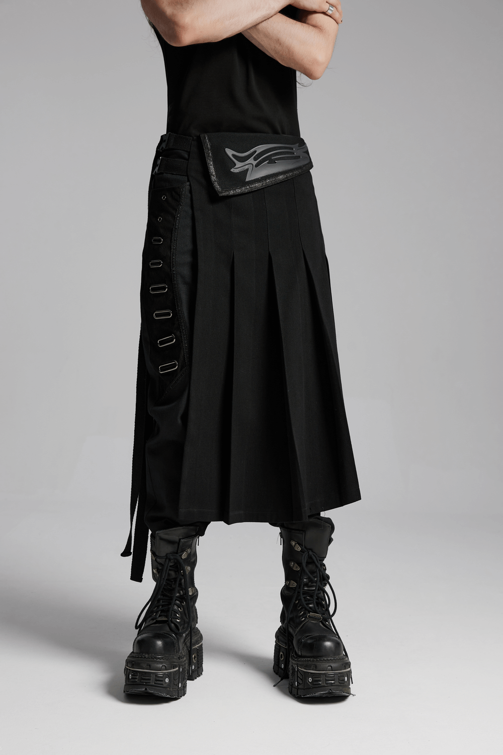 Cyberpunk black men's pleated half skirt with buckles, paired with bold footwear, showcasing avant-garde style.