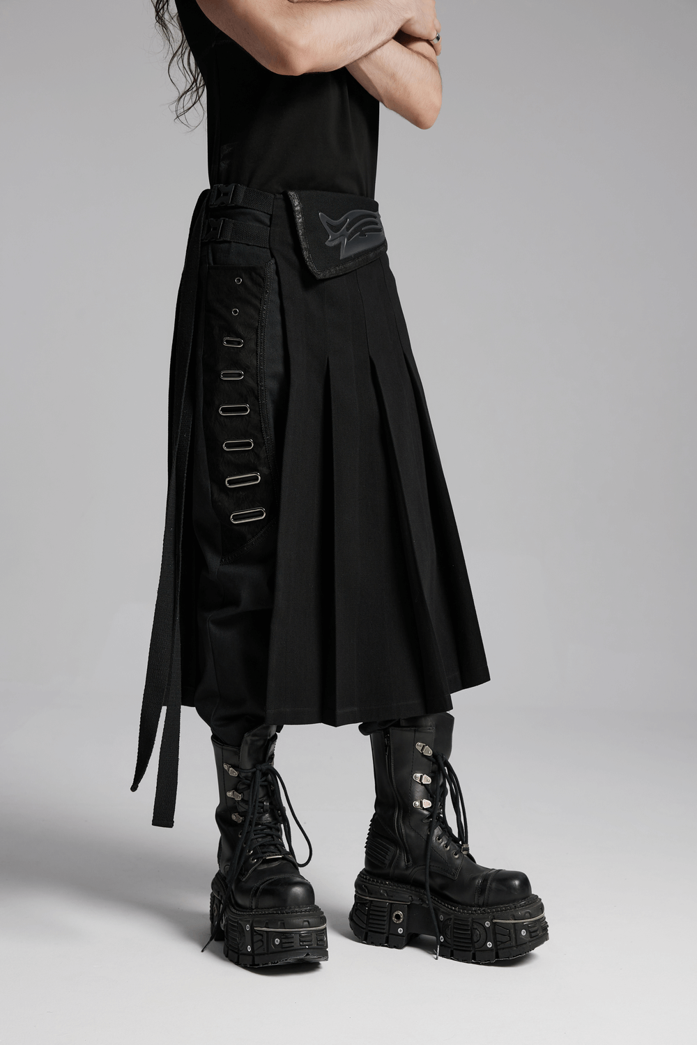 Cyberpunk black men's pleated half skirt with buckles, showcasing stylish 3D waist design and edgy boots.