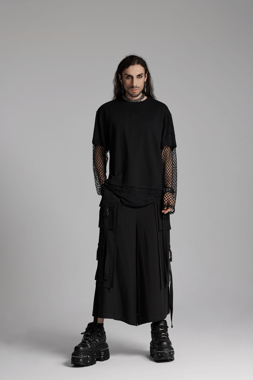 Edgy model showcasing cyberpunk black wide-leg pants with elastic waistband and mesh sleeves, exuding a bold fashion statement.