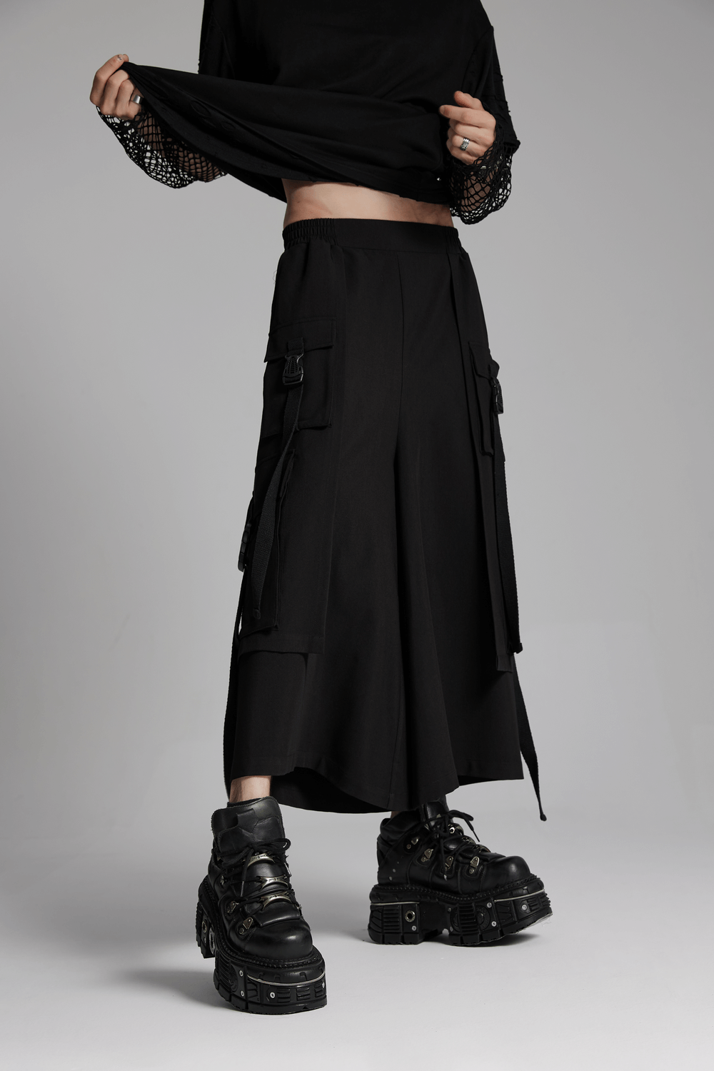 Cyberpunk black wide-leg cropped pants with side loops, paired with chunky black platform boots, showcasing an edgy style.