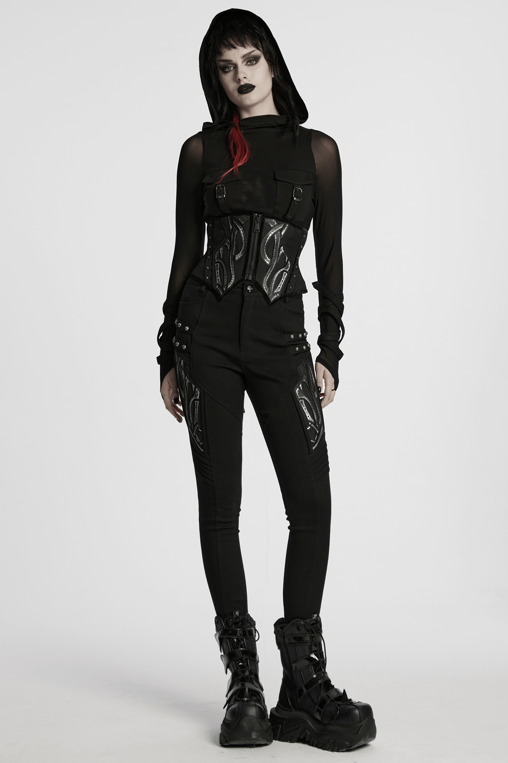 Model wearing a futuristic black mesh corset belt with studs paired with edgy black pants and chunky boots.