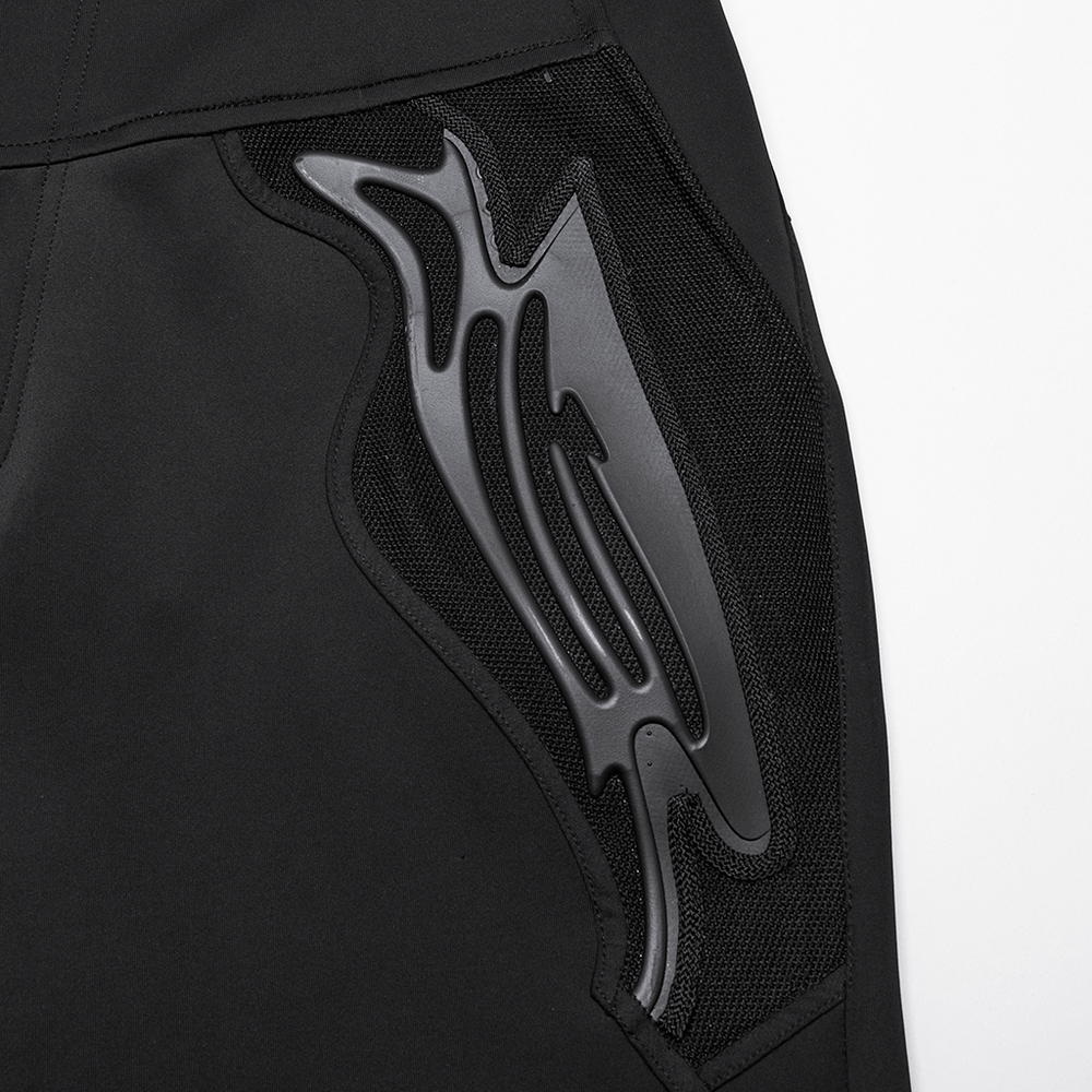 Close-up of cyberpunk-style black pants with unique mesh and rivet detailing for an edgy look.