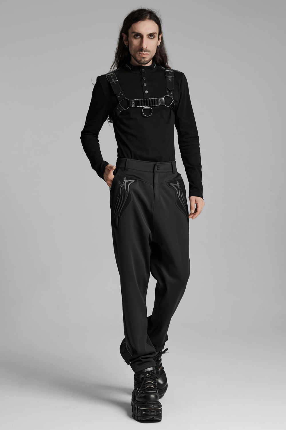 Cyberpunk-inspired model wearing dark gothic knitted pants with rivets and 3D pocket details, showcasing a stylish draped fit.