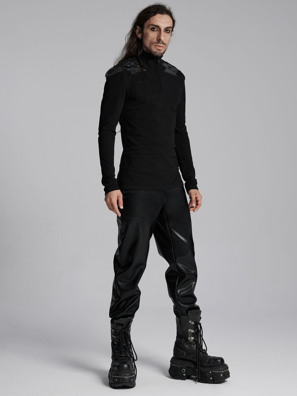 Cyberpunk male model in a black top with shoulder patches and zipper, showcasing a tactical and stylish look.