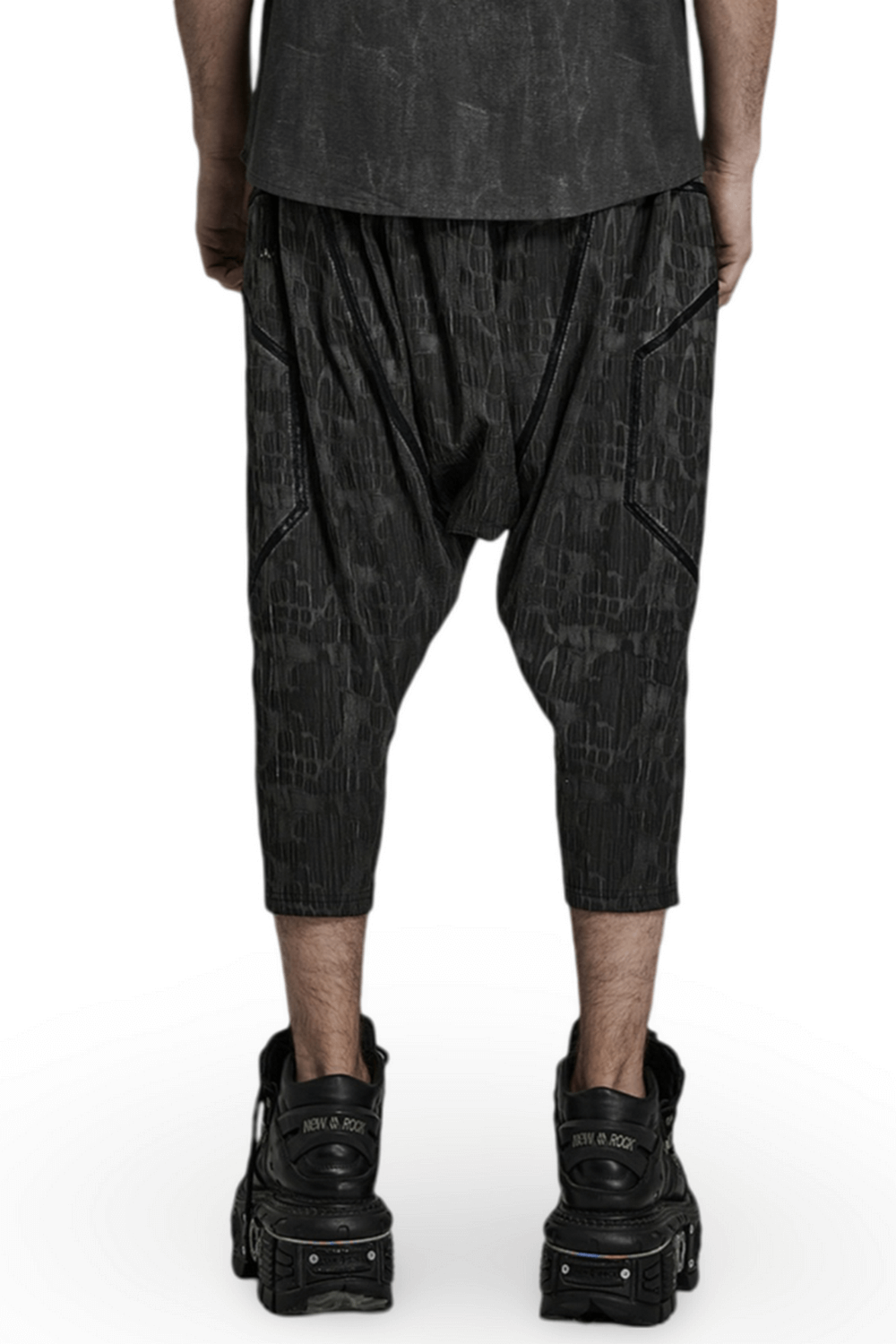 Back view of men's cropped snake texture drop-crotch trousers with layered design and elastic waistband.