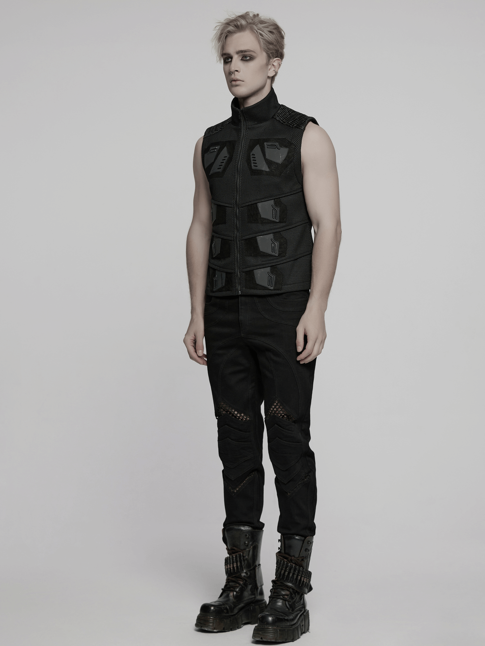 Cyberpunk mesh and leather vest with 3D rubber detailing, showcased by a model in edgy black outfit.