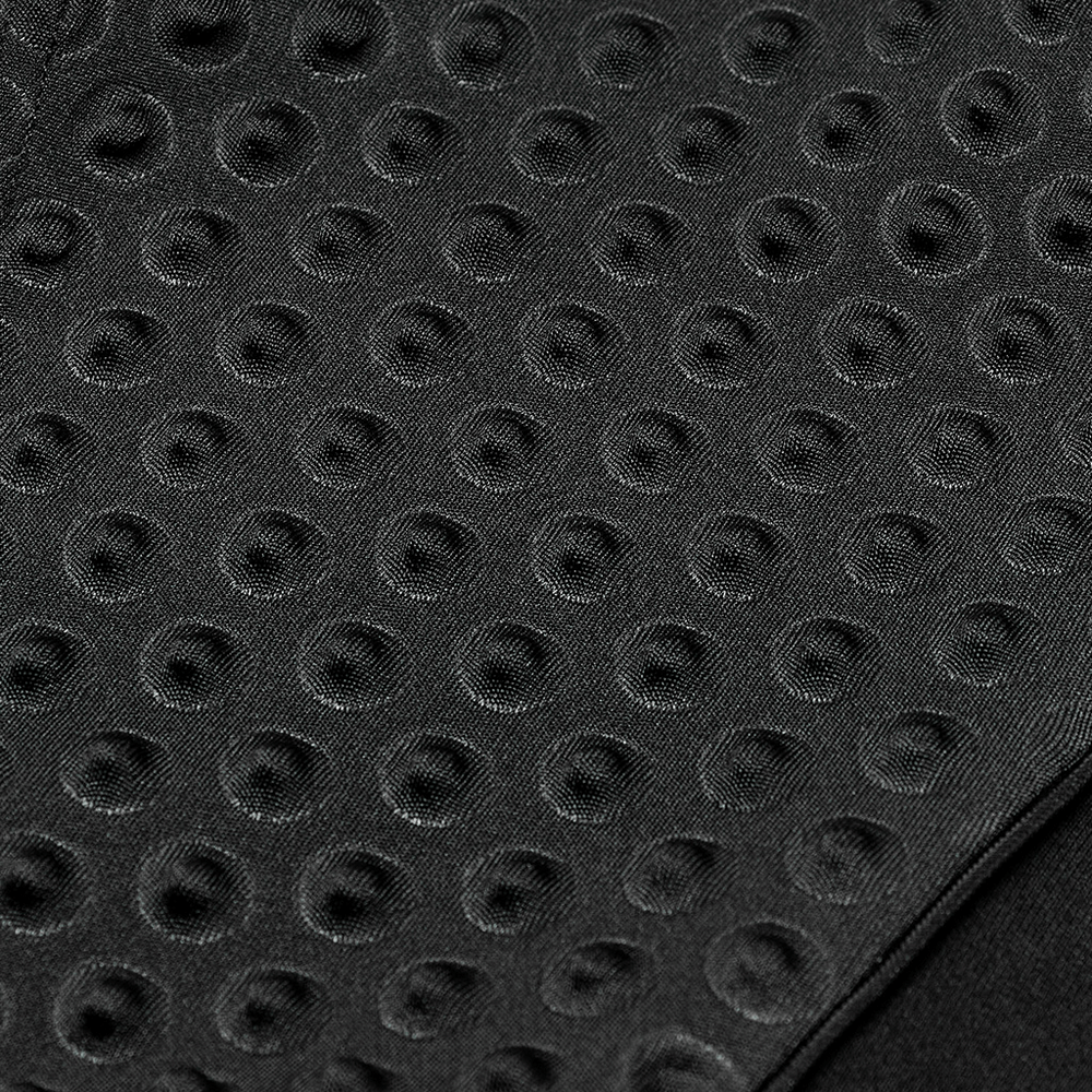 Close-up of textured black fabric with embossed circular patterns, adding a cyberpunk aesthetic.