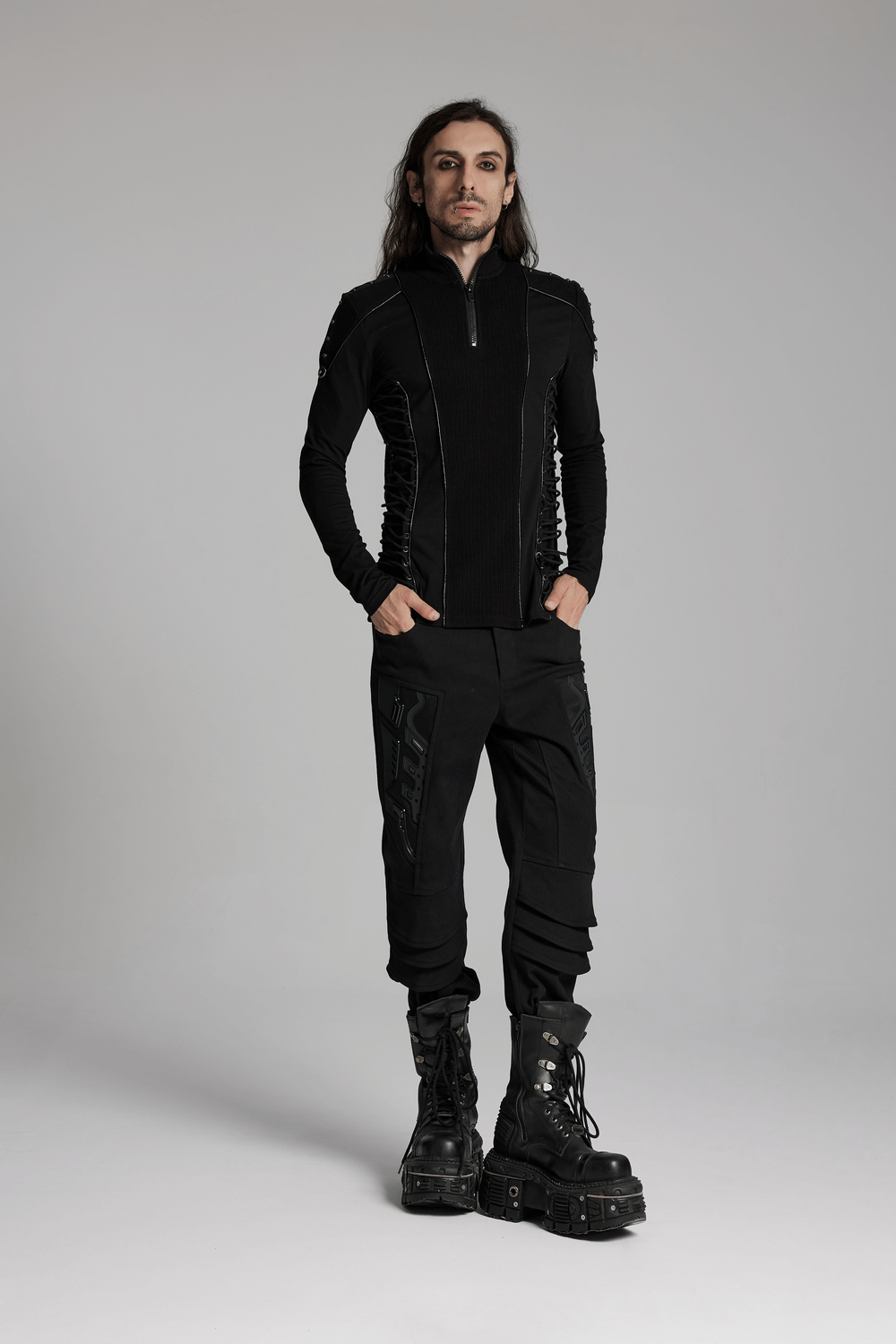 Man wearing a cyberpunk stand-up collar sweatshirt with rivet straps and black combat boots, standing confidently.