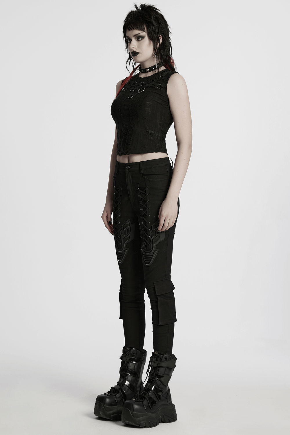 Model wearing Cyberpunk tight trousers with armor patch and calf pockets, styled with a black crop top and chunky boots.