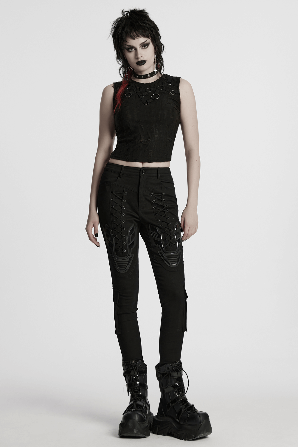 Model wearing cyberpunk tight trousers with armor patches and drawstrings, paired with a cropped top and chunky boots.