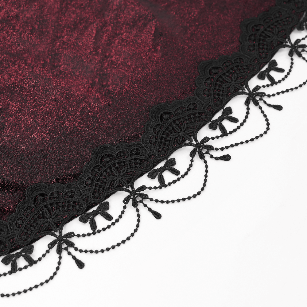 Close-up of dark red fabric with intricate black lace trim, showcasing elegant detailing for a gothic maxi coat.