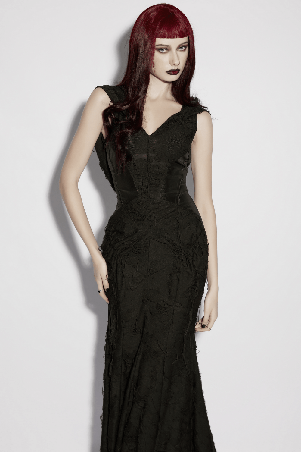 Alt Tag: Dark Fashion Hooded Gothic Fishtail Sleeveless Dress on model in black floor-length mermaid gown with textured fringe, dramatic silhouette