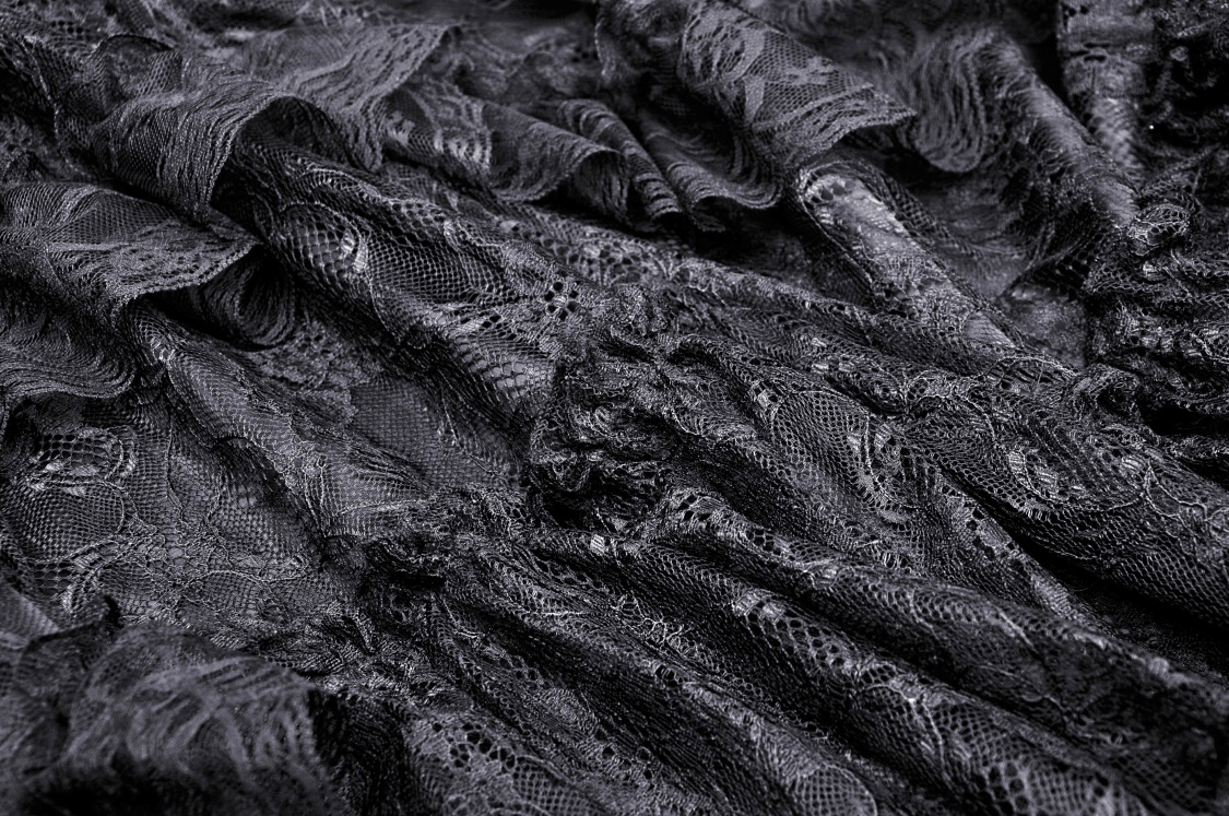 Elegant black lace fabric showcasing intricate floral patterns and flowing texture for gothic fashion.