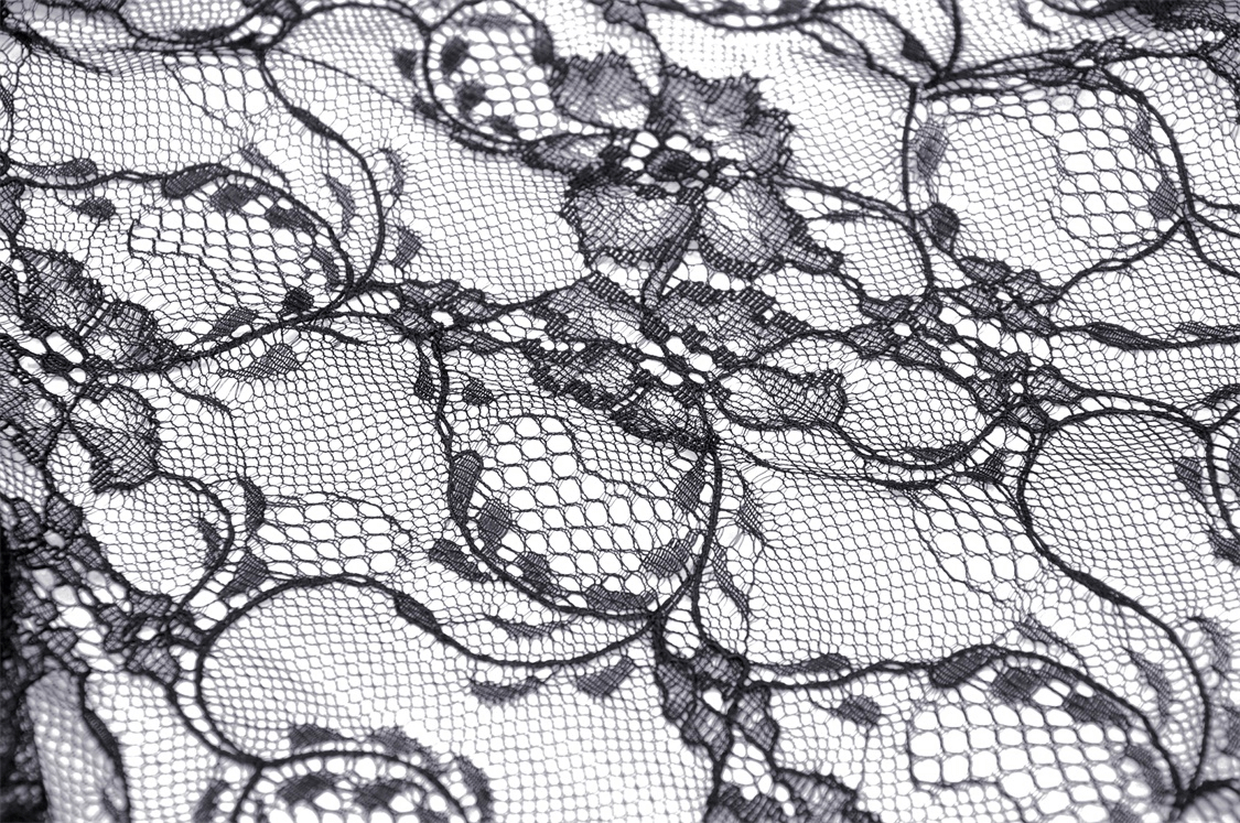 Close-up of delicate black floral lace fabric, perfect for a gothic Victorian style maxi skirt.