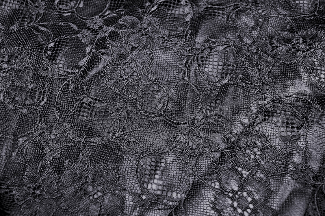 Close-up of dark floral patterned black lace fabric ideal for a Victorian goth maxi skirt.
