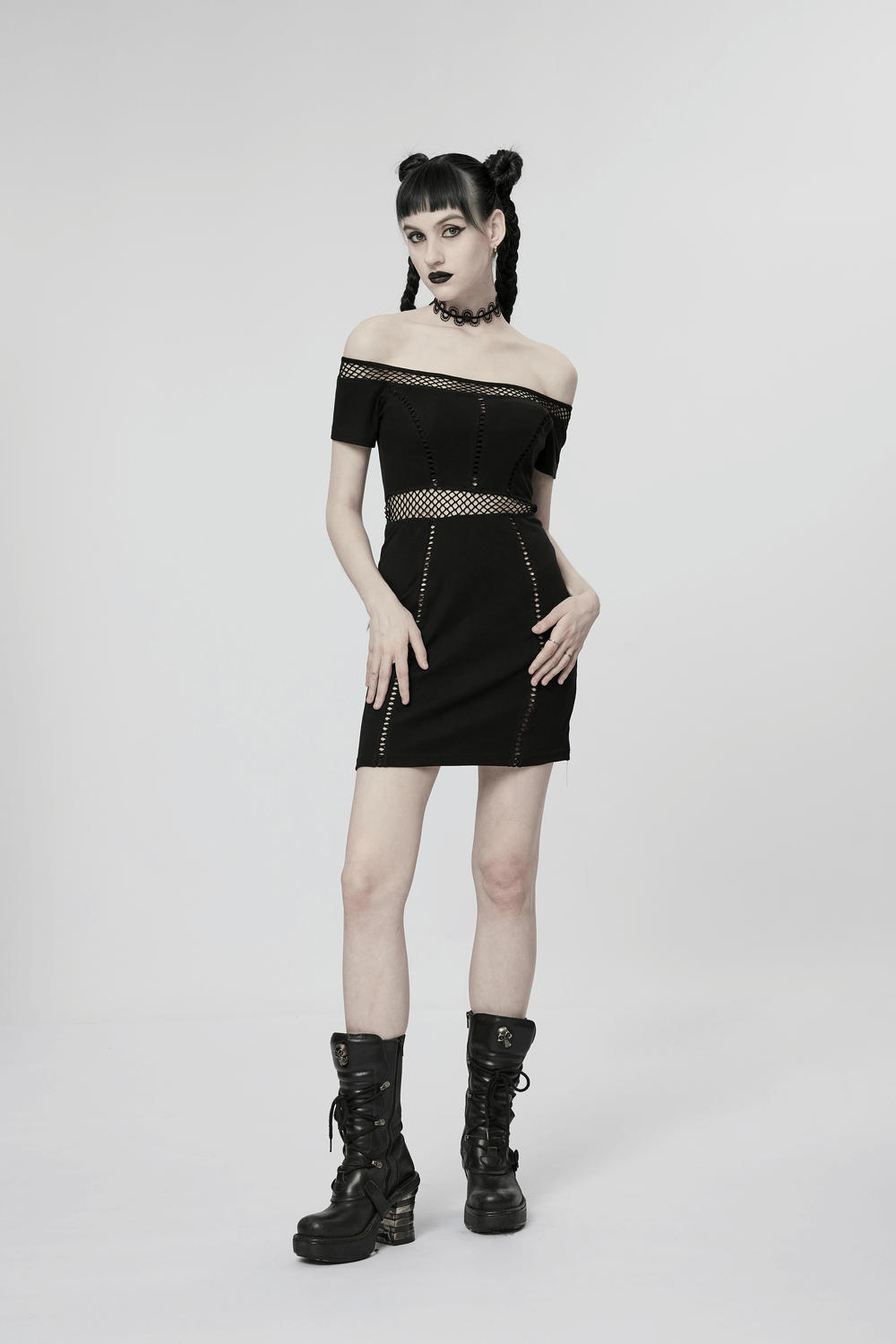 Gothic fashion model in off-shoulder black dress with lace details and chunky boots, exuding dark allure.