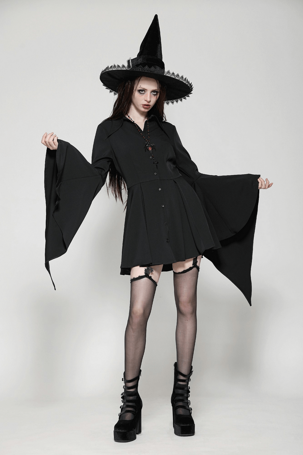 Gothic button-up dress with corset back, draped sleeves, and witch hat, embodying dark elegance and alternative style.
