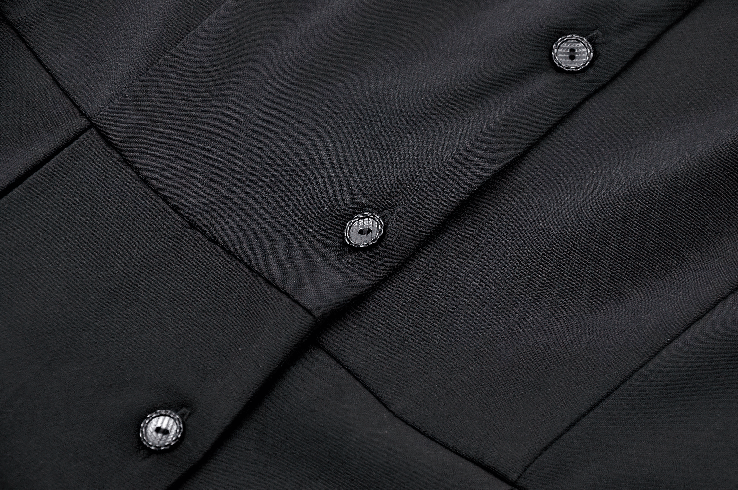 Close-up of dark gothic dress fabric featuring stylish black buttons for a chic and elegant look.