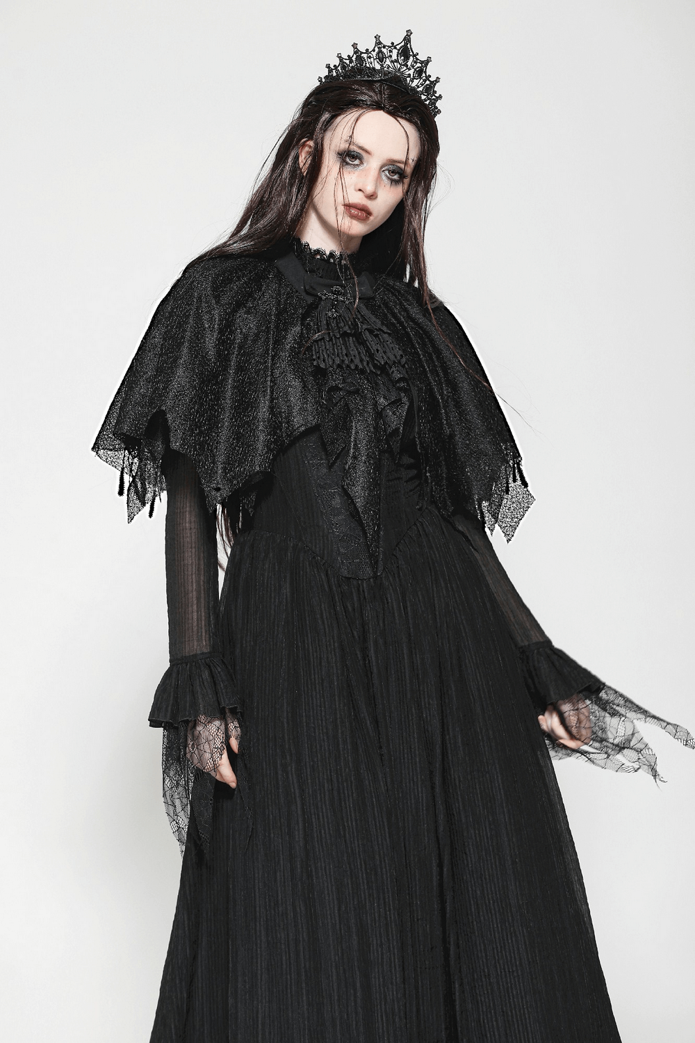 Dark goth fringed cape with lace details worn by model, exuding Victorian elegance and gothic charm.