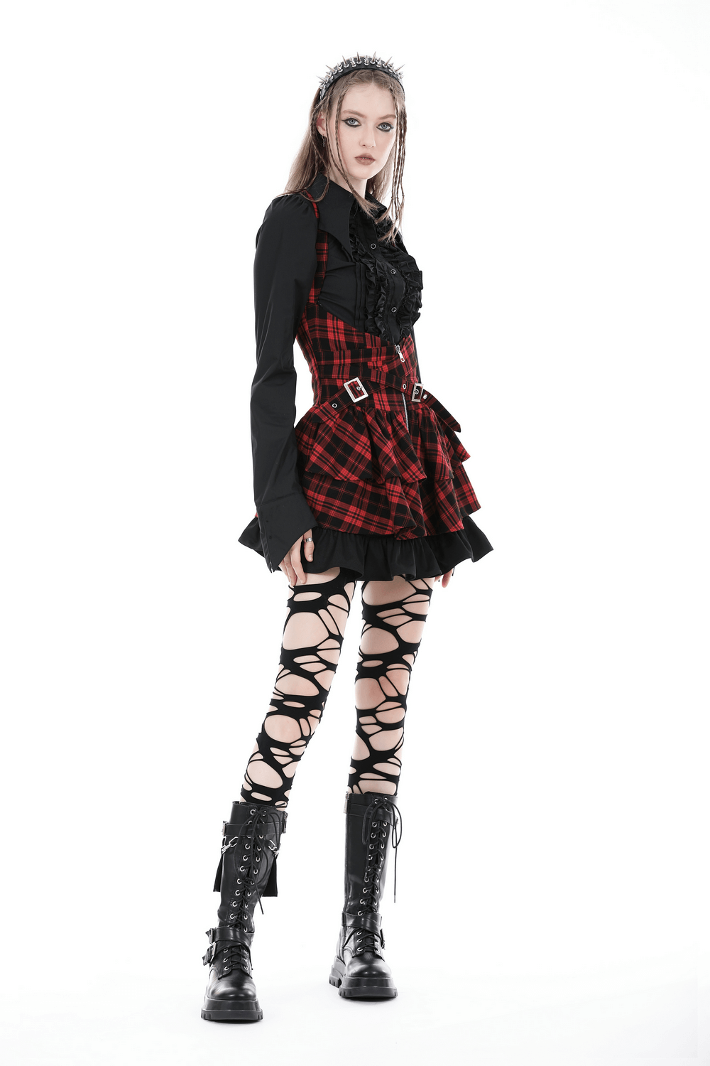 Gothic style outfit featuring a black ruffle blouse and plaid skirt with lace-up tights and combat boots.