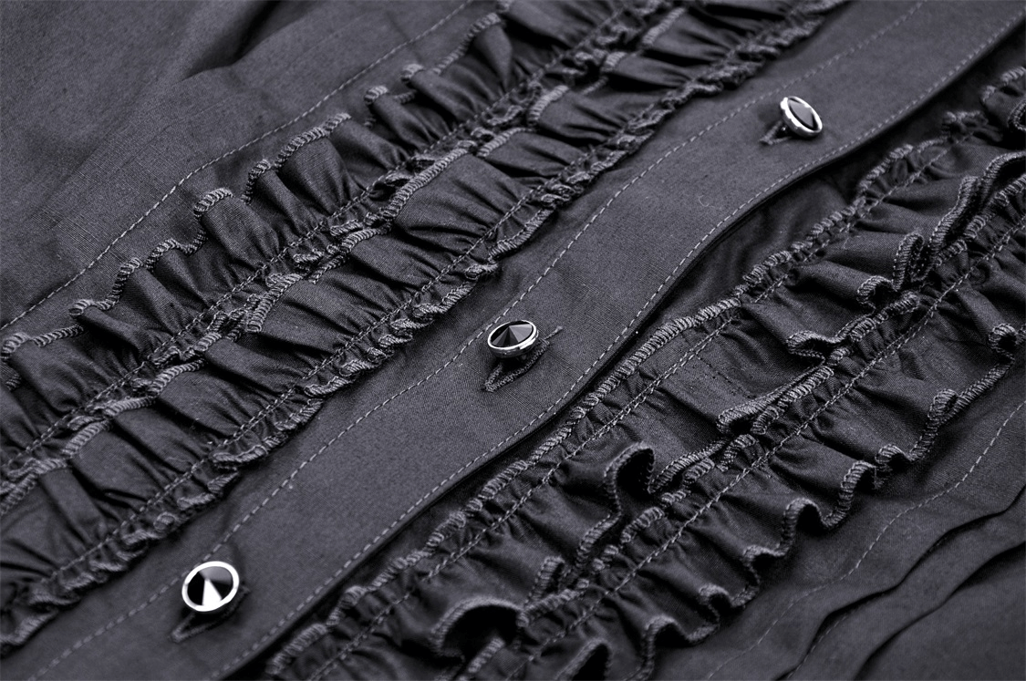 Close-up of dark gothic ruffle buttons on black blouse fabric, showcasing intricate detailing and elegance.