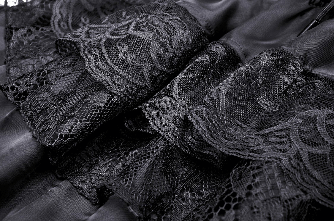 Close-up of dramatic black lace trim on a high-low chiffon skirt, showcasing its gothic elegance.