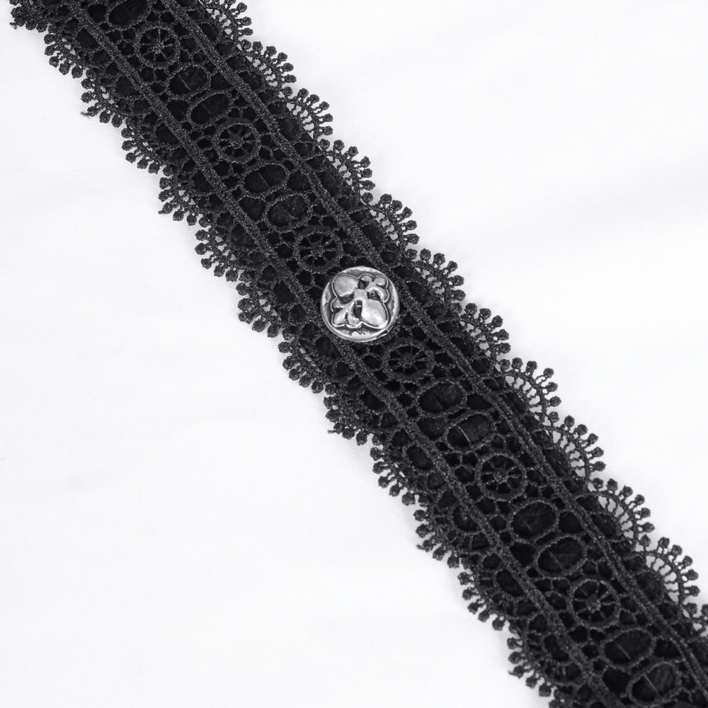 Close-up of black lace trim with button detail on a gothic layered dress.