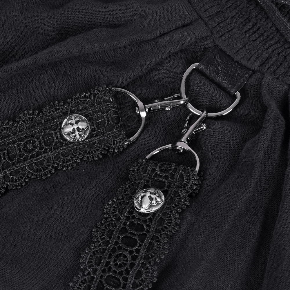 Close-up of dark gothic dress with intricate lace and metal chain accents.